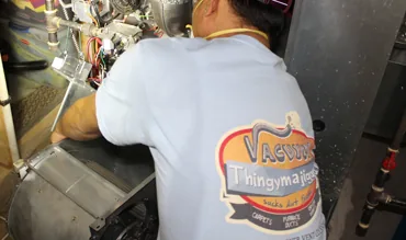 Technician cleaning a furnace blower